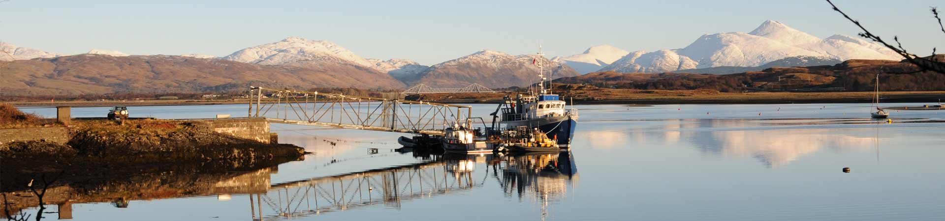 Image showing our pontoon with both vessels and a dive boat tied up during late autumn with snowy mountains